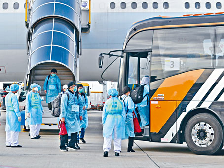 ■乘客全副裝備分批落機，帶着隨身行李登上旅遊巴。