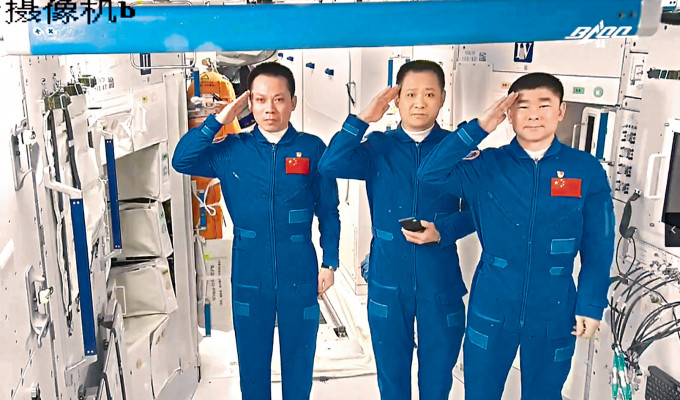 三名太空人離開太空站前向地面控制人員敬禮。