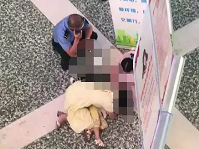 女童趴在地上，身旁一位女士和另一名女孩在哭泣和呼救。 网图