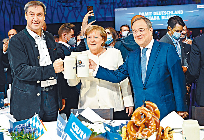 ■默克尔、基社盟主席索德（左）和联盟党总理候选人拉舍特（右），上周五在慕尼黑的拉票活动上举杯。法新社