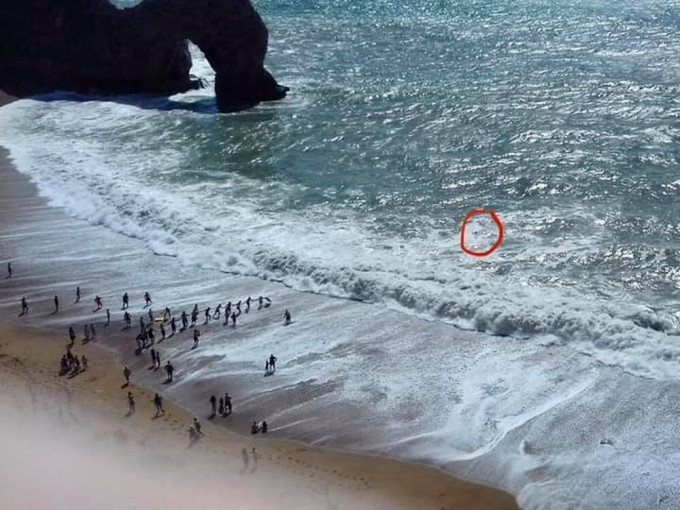 英国男泳客遭巨浪卷走，游不回来，被困海中，逾30人筑成人链成功救回。(FB图)