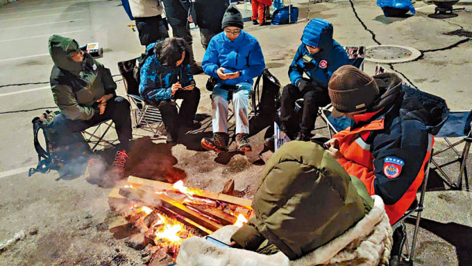 特區救援隊在嚴寒天氣下生火取暖，並獲國家救援隊提供熱食保持體溫。 