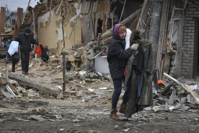俄羅斯火箭襲擊烏克蘭扎波羅熱，當地居民帶著他們的物品離開被毀的家園。AP