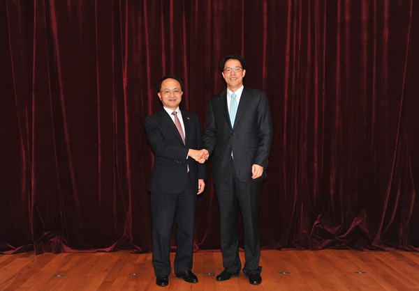 王志民（左）與張曉明握手合影。中聯辦網站
