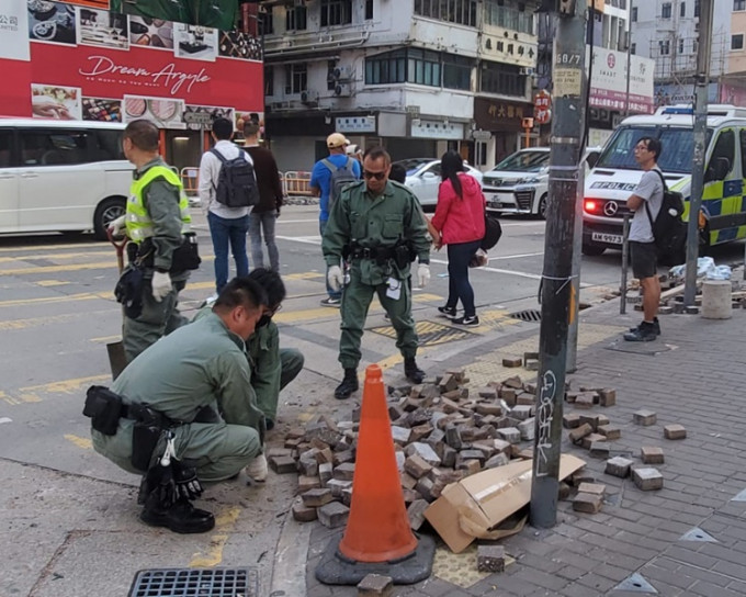 早警方及食環署清潔工人忙於清理馬路上的磚頭雜物。林思明攝