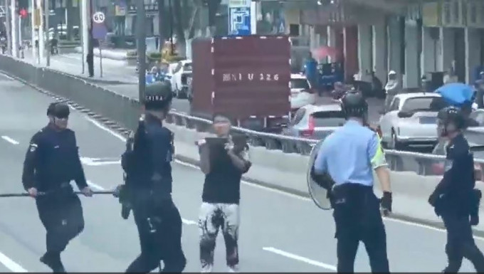 警员包围持刀男子，双方对峙。