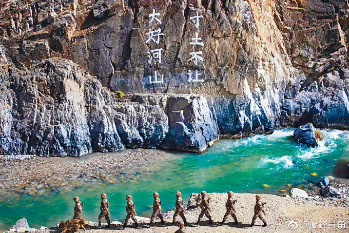中國士兵在去年爆發衝突的加勒萬河谷巡邏。壁上寫着「大好河山，寸土不讓」。