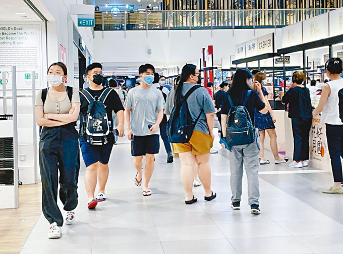 新加坡一家商场内的顾客周二仍戴口罩。