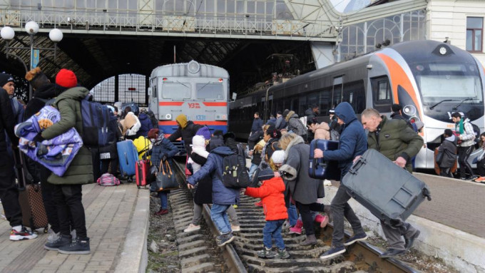 大批市民到火车站迫上火车逃往邻国。AP