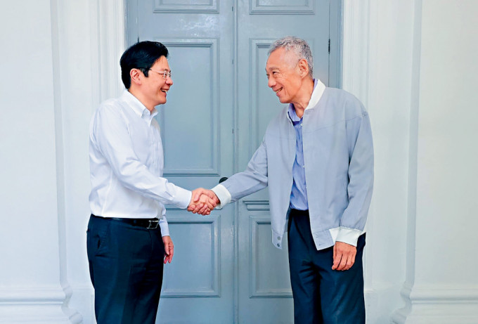 李顯龍上周四主持總理任內最後一次內閣會議，與繼任人黃循財握手。