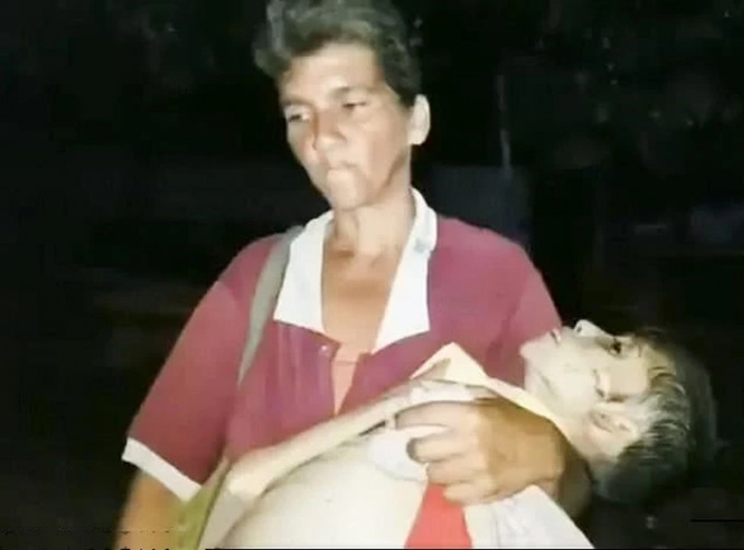 一位妈妈抱着严重营养不良女儿尸首到殓房。(网图)
