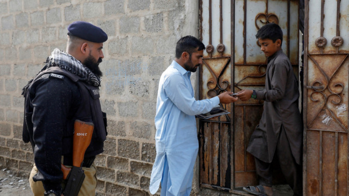 在卡拉奇郊區一個阿富汗營地，巴基斯坦政府官員和警察逐戶敲門檢查身份證。 路透社