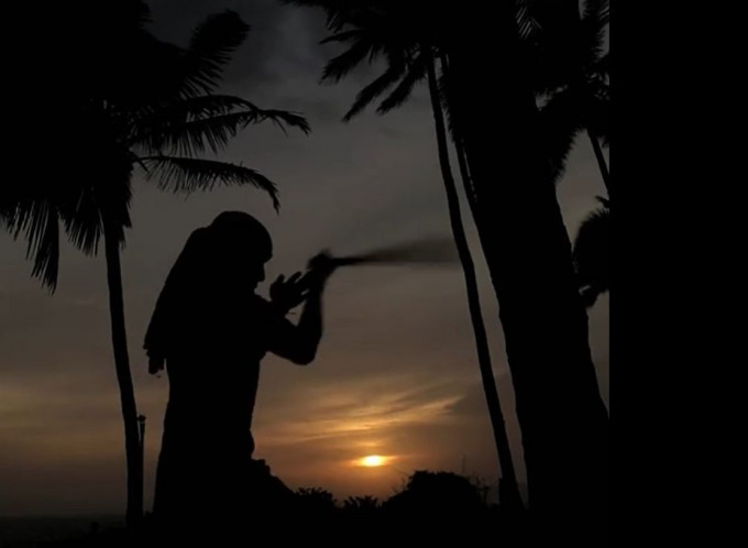 乔靖夫二○一三年在印度拍摄《功夫传奇》期间，在夕阳及椰树之下，于海边用木头「练刀」。