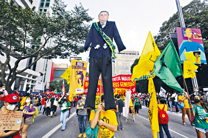 ■示威者在巴西圣保罗市，举起巨型的博索纳罗纸板人游行。