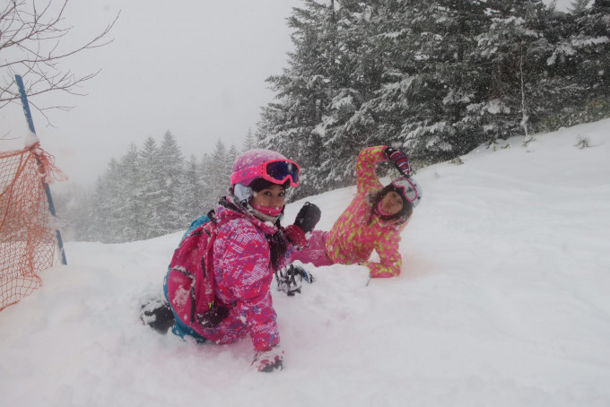 寇鸿萍(左)与女儿挑战高难度滑雪。