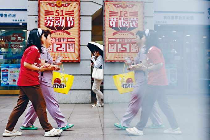 五一期間，遊客拎着食物走在上海南京東路。