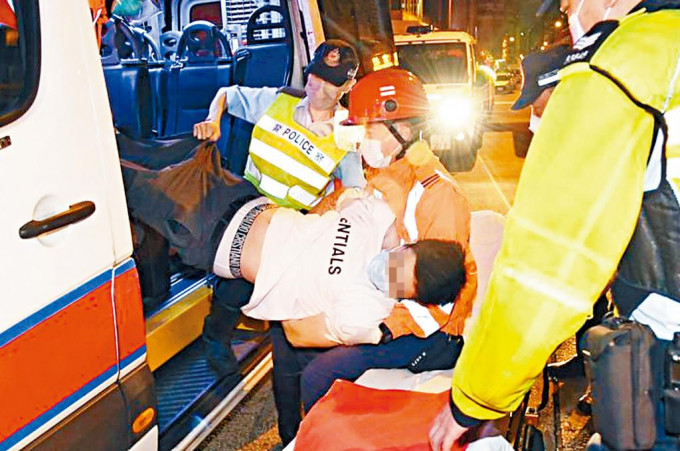 涉案休班水警醉倒警車上，人員須合力將他抬上救護牀送院。