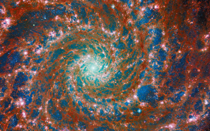 韦伯与哈勃太空望远镜联手捕捉到幻影星系的缤纷螺旋影像。 