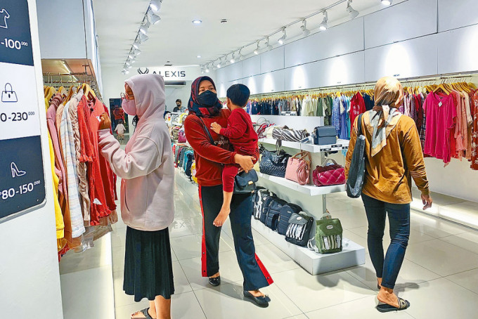 在印尼首都耶加达的商场，昨日仍见顾客戴口罩。