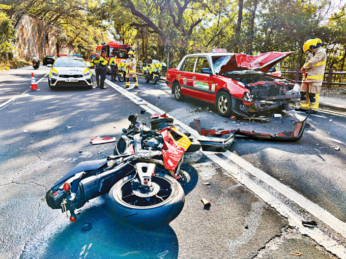 電單車與的士迎頭相撞後，兩車損毀嚴重，零件散滿一地。
