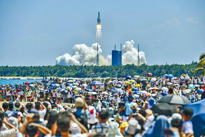 民眾在海南文昌淇水灣沙灘觀看火箭點火升空。