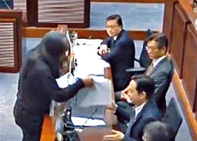 梁國雄於二〇一六年，在立法會會議上搶去時任發展局副局長馬紹祥桌上的文件。