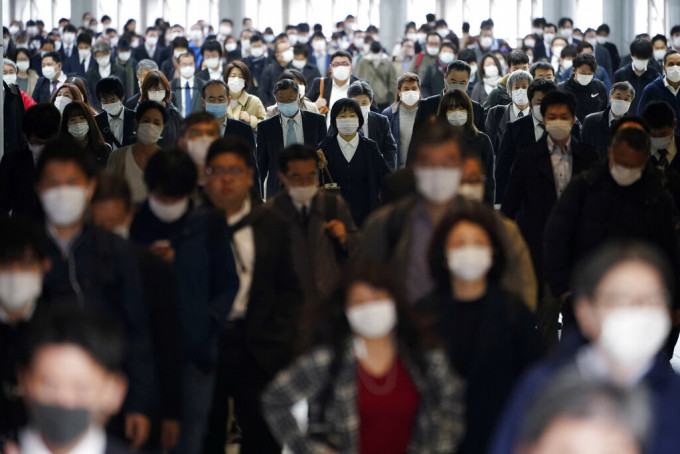 日本民衆戴口罩外出防疫。AP