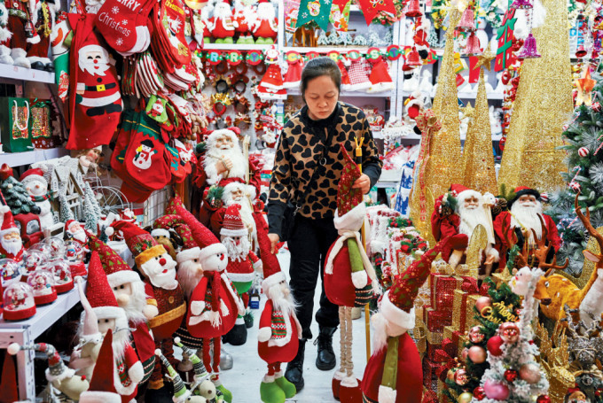 北京某商場聖誕裝飾品攤位上，供應商正做產品分類。