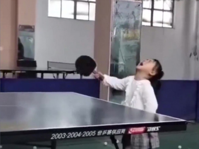 3岁女孩哭着打乒乓，仍精准接到。(网图)