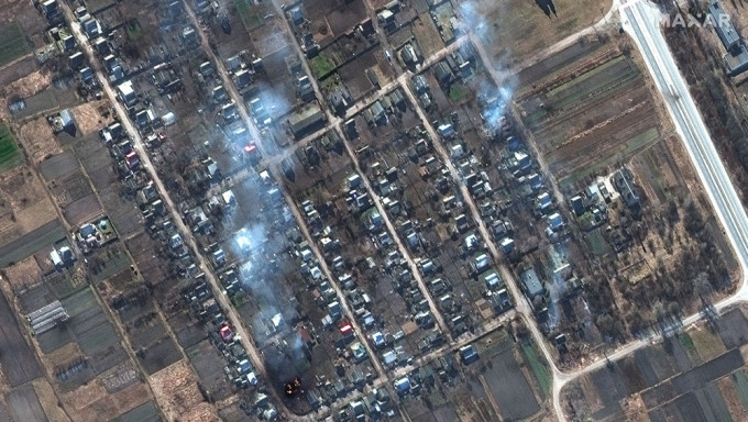 卫星图像显示乌克兰Rivnopillya田野中燃烧的房屋和撞击坑。AP图
