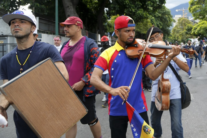 阿特亚加在反政府示威中演奏。AP图片