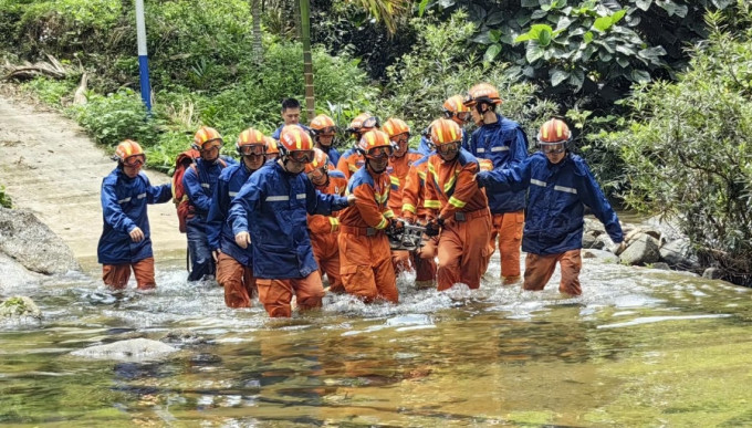救援人員將傷者抬出森林。