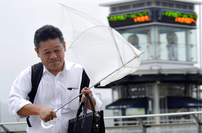 磐城市民众外出遇狂风大雨。AP图片