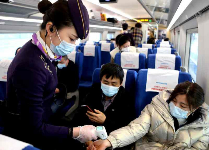 上海高鐵職員按疫情防控要求為旅客測量體溫。新華社