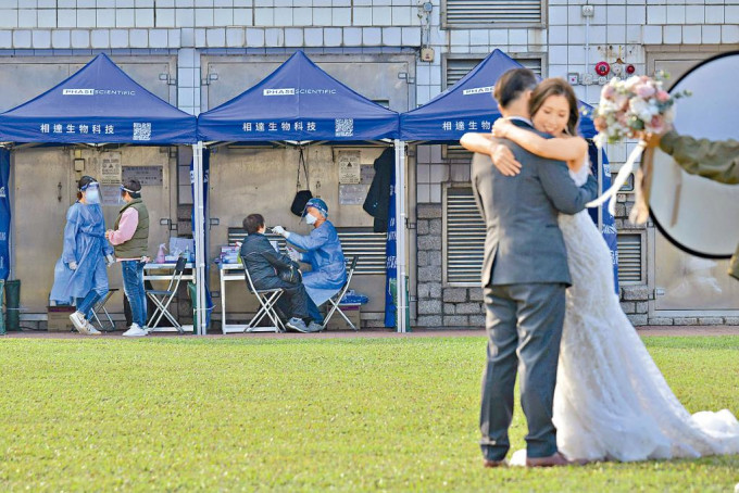 政府添馬公園流動採樣站外，有一對新人無懼近期疫情爆發，仍享受拍攝婚紗照時刻。