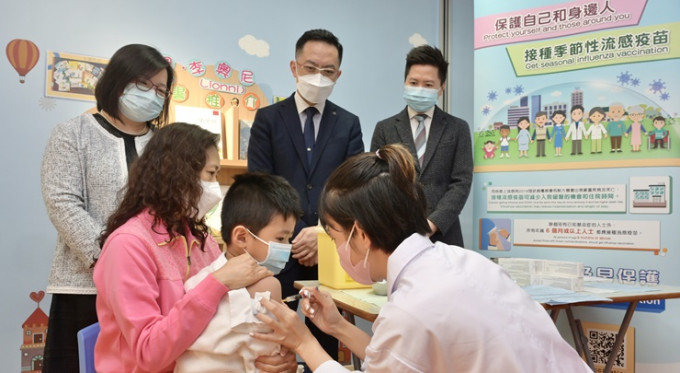 林文健(后排中)与徐乐坚(后排右)视察幼稚园的流感疫苗接种安排。政府新闻处图片