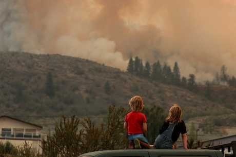 加拿大卑詩省一些居民遠望消防員對抗山火。路透社