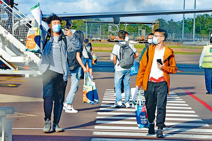 一批國際學生昨日在達爾文機場步下停機坪。