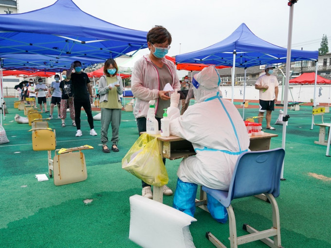 市民在扬州市广陵区一小学进行核酸检测取样。新华社