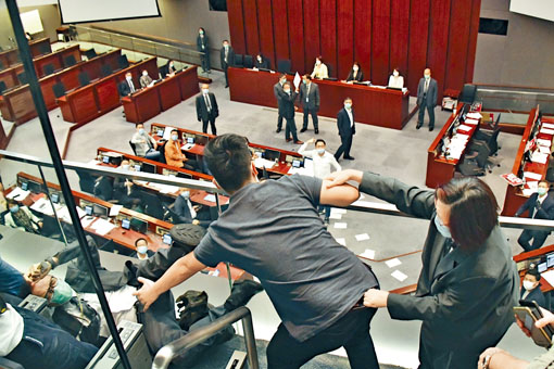 ■工黨主席郭永健(中)向會議室擲紙張時，一名保安疑失平衡跌在地上。