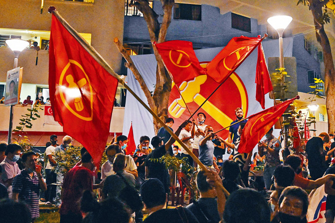 ■工人黨支持者昨天凌晨在組屋區揮舞黨旗慶祝。