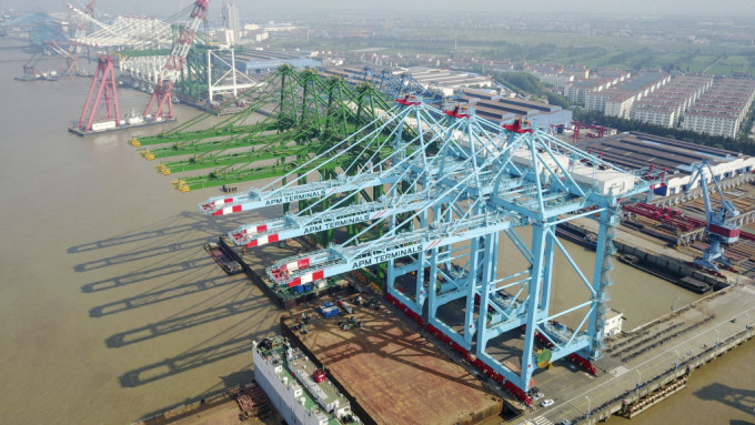 上海振華重工（ZPMC）製造的岸邊起重機排列在生產碼頭上。 新華社