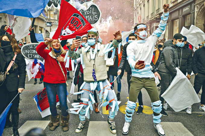 法國里昂周一有一批在身上穿戴口罩的示威者，抗議夜店、酒吧關閉。