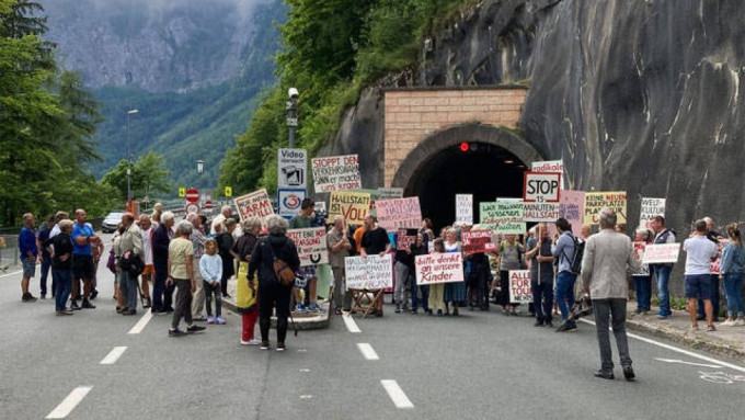 哈爾施塔特居民堵塞一條公路隧道口示威，舉起標語牌要求限制旅遊。網上圖片