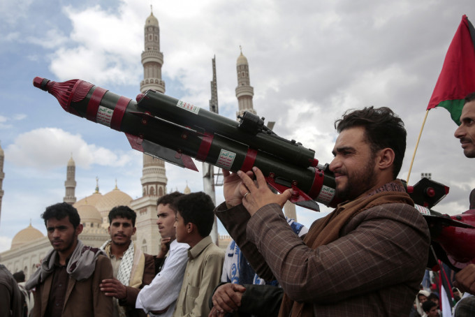 胡塞武装的支持者手持模拟的火箭发射器。美联社