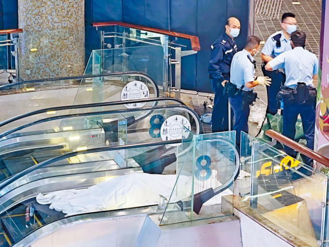 老婦飛墮扶手電梯口身亡，警方以白布遮蓋遺體調查。