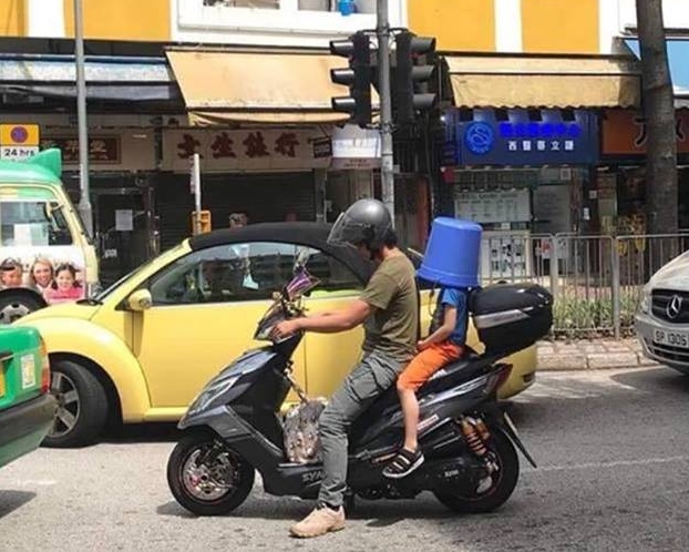 有網民在大埔發現，有電單車後座小童竟蓋上膠水桶，疑代替頭盔，引起熱議。fb群組「PLAY HARD 玩硬」
