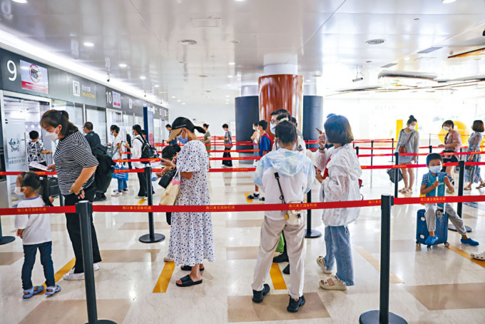 返程旅客在海口美蘭機場候機樓內準備接受安檢。