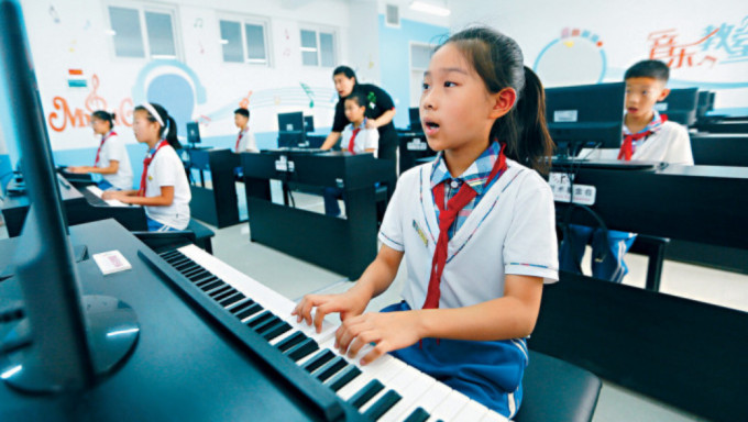 钢琴业走下坡，学琴人数锐减。 图为山东小学生们在学习弹钢琴。