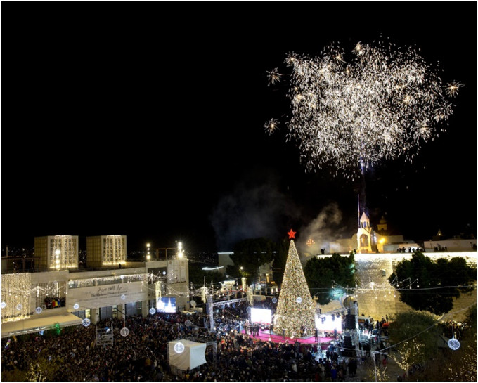 在耶稣出生地马糟广场的圣诞教堂外圣诞树亮灯还放烟花。AP
